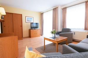 TV a/nebo společenská místnost v ubytování Ferienwohnung Ostseebutt mit Terrasse im Kaiserhof 2