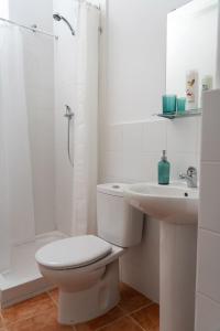 a white bathroom with a toilet and a sink at Centro apartamento 2-B in Huelva