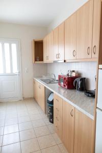 a kitchen with wooden cabinets and a red microwave at Airport city center 2 in Spata +11 photos