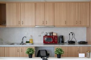 a kitchen with a red microwave on a counter at Airport city center 2 in Spata