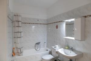a bathroom with a sink and a toilet and a bath tub at Airport city center 2 in Spata