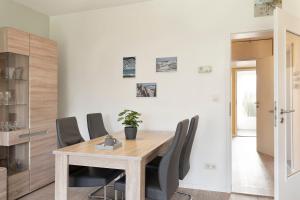 a dining room with a wooden table and chairs at Seestern in Grömitz