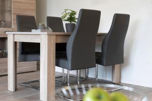 a dining room table with four black chairs at Seestern in Grömitz