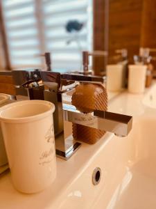 a cup of coffee sitting on a bathroom counter with a sink at Residenze Lizzeri-Casa Moniga in Moniga +55 photos