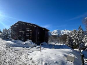 a black building in the snow with snow at Studio Carroz d'Arâches 4 pers in Arâches-la-Frasse