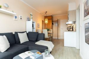 a living room with a blue couch and a kitchen at Haus Panorama Laboe Nr 21 in Laboe