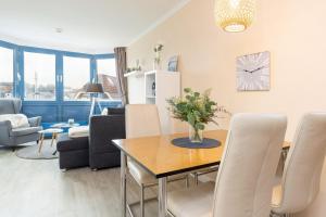 a living room with a dining room table with chairs at Haus Panorama Laboe Nr 21 in Laboe