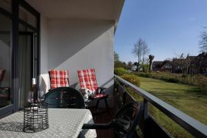 a patio with a table and chairs on a balcony at Schützenweg 6 Strandhafer in Kellenhusen