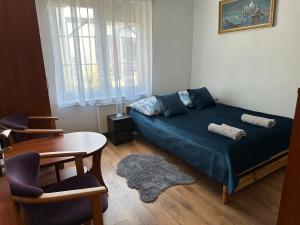 a bedroom with a bed and a table and chairs at Błękitna Fala in Ustka