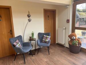 ein Wartezimmer mit zwei Stühlen und einem Teddybär in der Unterkunft Ihr Ferien Hotel Brunnenhof in Suhlendorf
