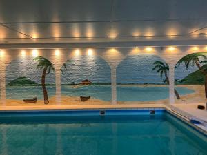 einen Pool mit einem Palmenmilch in der Unterkunft Ihr Ferien Hotel Brunnenhof in Suhlendorf + 37 Fotos