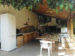 a kitchen with a table and a white refrigerator at Villa Manolia in Orfánion +23 photos