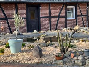 einen Garten vor einem Haus mit einem Holzzaun in der Unterkunft Ihr Ferien Hotel Brunnenhof in Suhlendorf