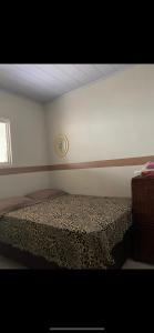 een slaapkamer met een bed en een klok aan de muur bij Casa Compartilhada in Garanhuns