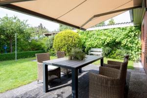 a table and chairs under an umbrella on a patio at Kellenhüs in Kellenhusen