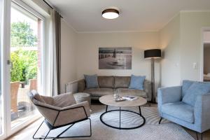 a living room with a couch and chairs and a table at Kellenhüs in Kellenhusen