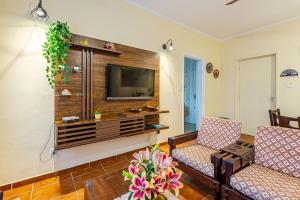 sala de estar con TV y 2 sillas en Apê Clássico e Aconchegante no Guarujá - 350 m da praia, en Guarujá 31 fotos más