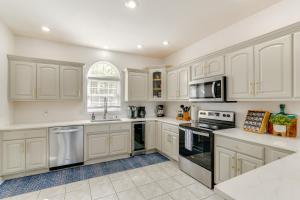 a white kitchen with white cabinets and appliances at Private Dock and 4 Decks Lake Ozark Retreat! in Gravois Mills