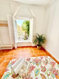 Habitación vacía con ventana grande y cama en Centro apartamento 2-C, en Huelva