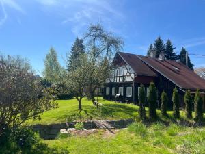 a house on a green field with trees in front of it at Chalupa v Cíšařským in Golčŭv Jeníkov