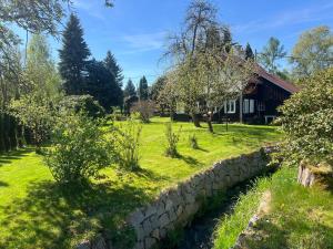 a garden with a stone wall and a house at Chalupa v Cíšařským in Golčŭv Jeníkov