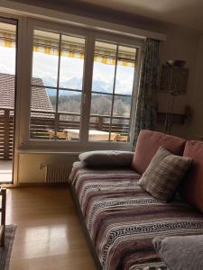 un soggiorno con divano e una grande finestra di Charming studio with a view a Flims