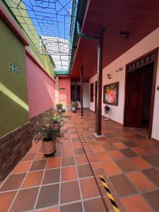 an empty hallway of a building with plants on the floor at Hotel Los Jacintos in Buga