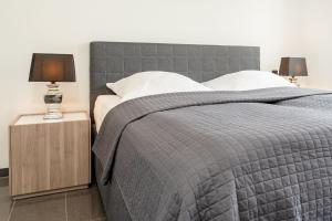 a bedroom with a bed with a gray comforter at Strandvilla Augustusbad Meerverliebt in Scharbeutz