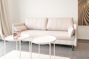 a living room with a couch and two tables at Strandvilla Augustusbad Meerverliebt in Scharbeutz