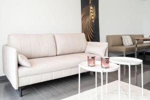 a living room with a couch and two tables at Strandvilla Augustusbad Meerverliebt in Scharbeutz