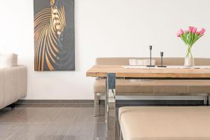 a dining room with a table and a vase of flowers at Strandvilla Augustusbad Meerverliebt in Scharbeutz +31 photos