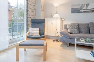 a living room with a chair and a couch at Seesternresidenz- Strandliebe Scharbeutz in Scharbeutz