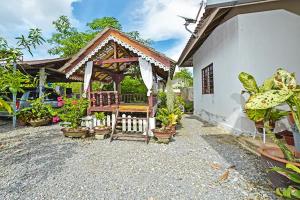 a house with a gazebo with potted plants at Homestay Masha Padang Besar in Padang Besar