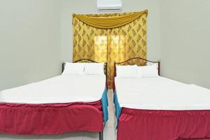 two beds sitting next to each other in a room at Homestay Masha Padang Besar in Padang Besar