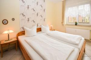 a bedroom with two beds with white sheets and a window at Seepark Störtebekers Nest in Scharbeutz