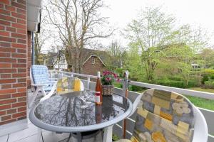a patio table and chairs on a balcony at Seepark Störtebekers Nest in Scharbeutz +17 photos