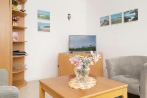 a vase of flowers on a table in a living room at Kaiserhof 42-44 Meereskrabbe in Kellenhusen