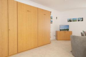 a room with wooden wardrobes and a television at Kaiserhof 42-44 Meereskrabbe in Kellenhusen