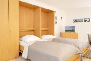 two beds in a bedroom with wooden cabinets at Kaiserhof 42-44 Meereskrabbe in Kellenhusen