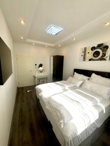 a large white bed in a room with a washing machine at Renovierte und klimatisierte 70qm City-Wohnung mit Balkon in Saarbrücken