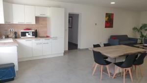 a kitchen and dining room with a wooden table and chairs at L'Hacienda in Manciet