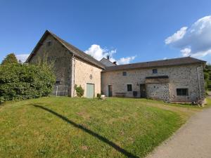 an old stone building with a grass yard at Terre de Plaisirs in Forgès