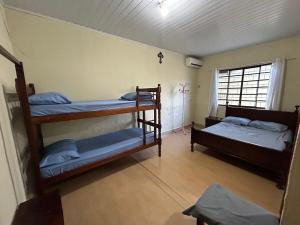 a room with two bunk beds and a window at Casa ampla com 02 suítes e 01 quarto próx das Cataratas e Aeroporto in Foz do Iguaçu