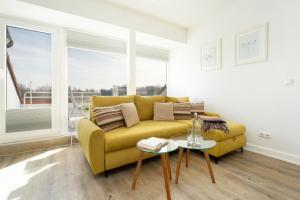 a living room with a yellow couch and a table at Golfresidenz Ostseebude in Grömitz
