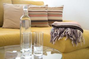 a glass table with a bottle and two glasses on a couch at Golfresidenz Ostseebude in Grömitz +37 photos
