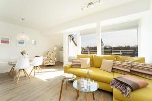 a living room with a yellow couch and a table at Golfresidenz Ostseebude in Grömitz
