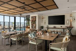 a restaurant with tables and chairs and a flat screen tv at Courtyard by Marriott Casablanca Downtown in Casablanca