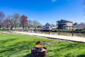 a tree stump in the grass with a house in the background at Waterfront Port Clinton Cottage with Fire Pit! in Port Clinton