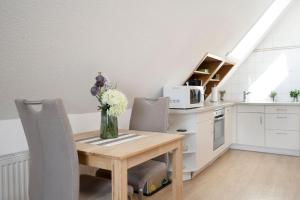 a kitchen with a wooden table with a vase of flowers at Hasenkamp 18 Krabbe in Grömitz