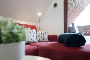 a red couch with pillows on it in a living room at Hasenkamp 18 Krabbe in Grömitz